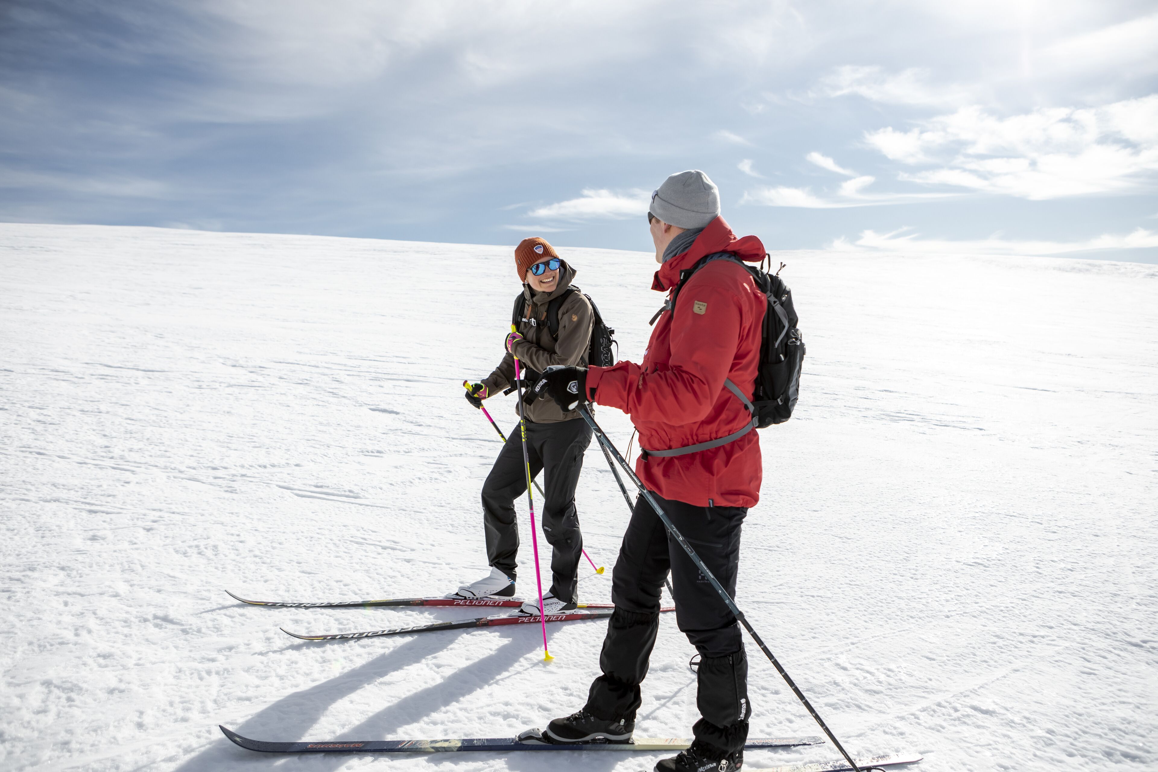 Deux personnes font du ski sur une pente enneigée.