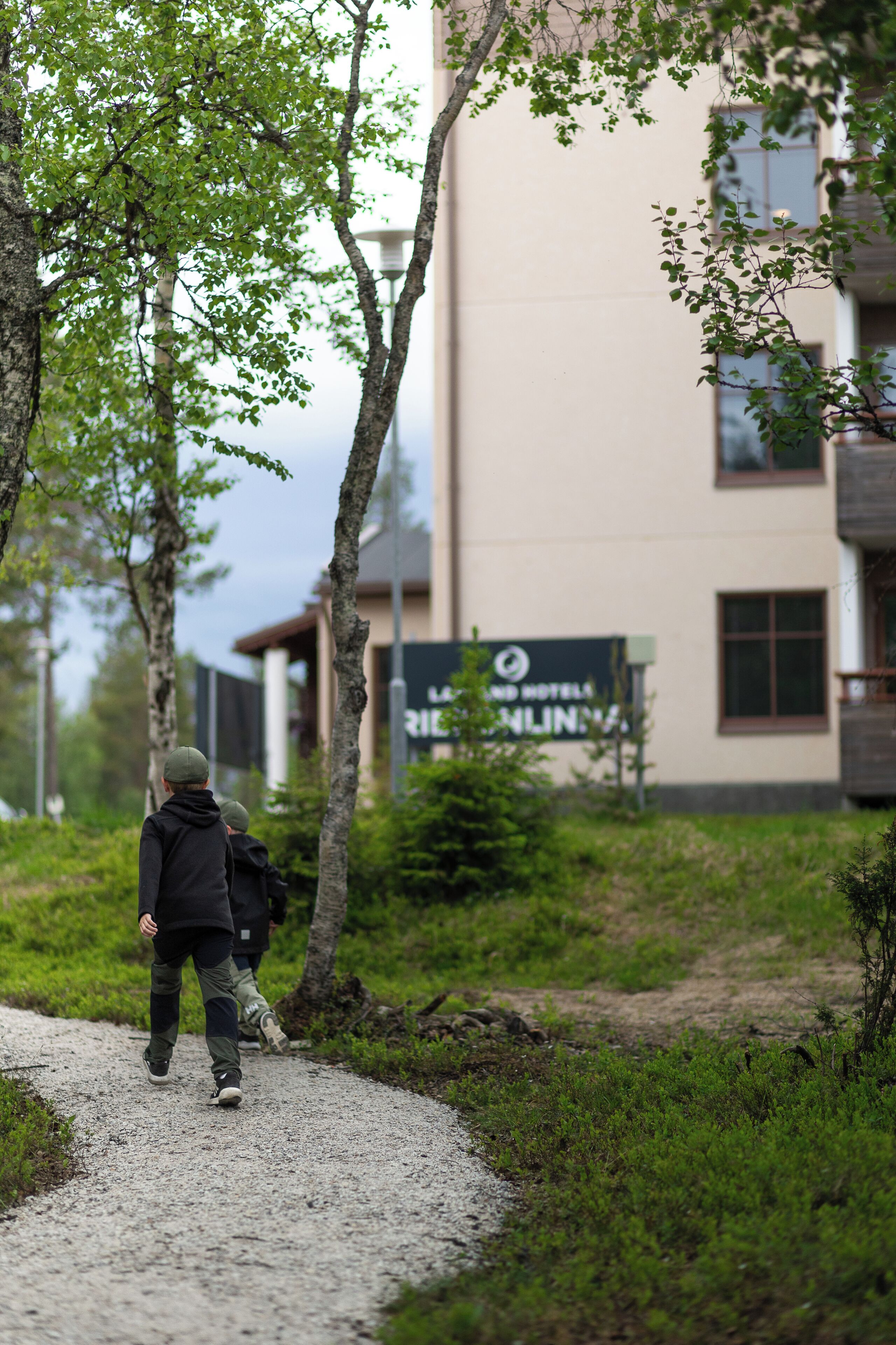 A pathway leading to a building with a sign indicating a hotel.