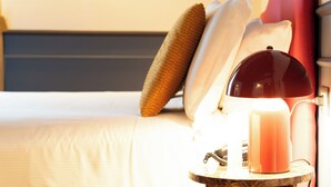 A bed with pillows, a bedside lamp, and a candle. - JOIVY Together Florence Secret Nest (Florence)
