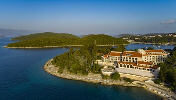 A coastal hotel with a large building featuring multiple balconies and a view of the sea.