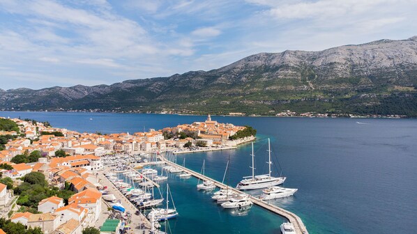 A coastal town with a marina, boats, and a mountainous backdrop. - Aminess Liburna Hotel  (Korcula)