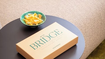 Un llibre amb el títol 'BRIDGE' sobre una taula rodona, amb un bol de menjar a prop.