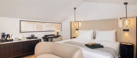 A modern hotel room with a bed, bedside tables, a desk, and a chair.