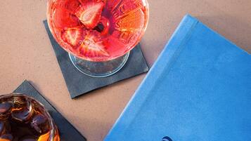 A blue menu and two glasses of beverages on a table.