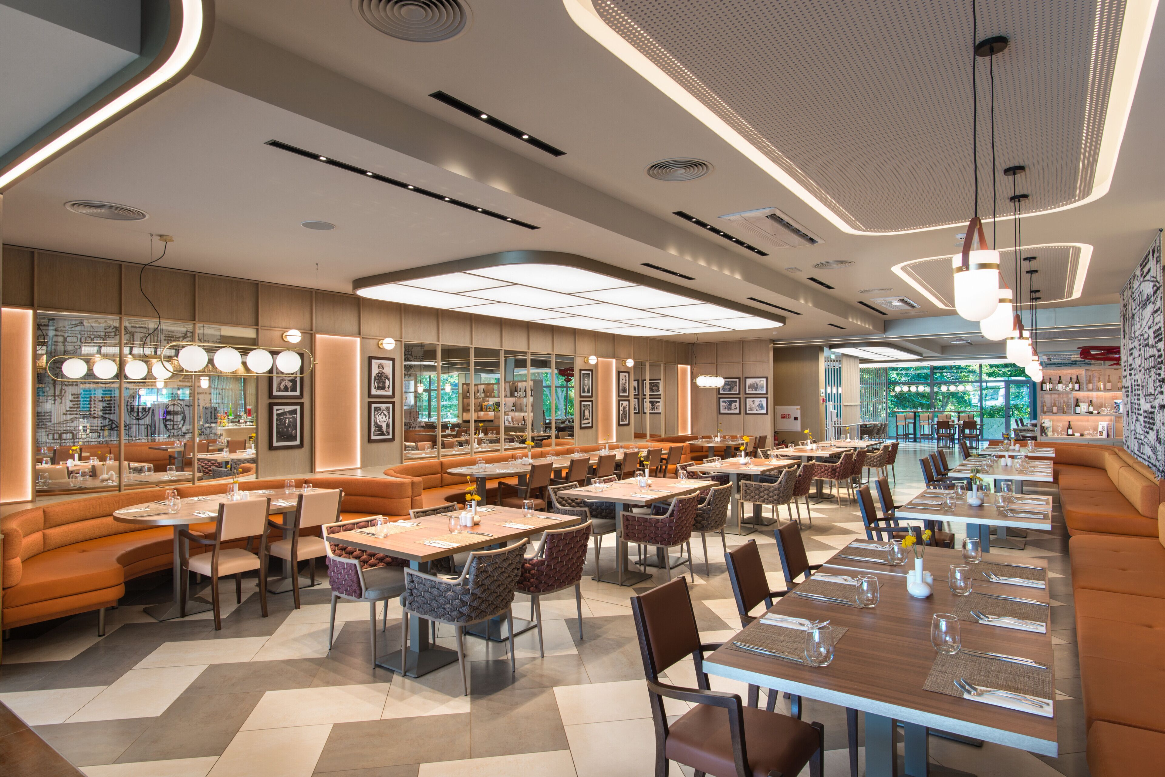 Un restaurante moderno con diversas opciones de asientos, incluyendo cabinas, mesas y taburetes altos.