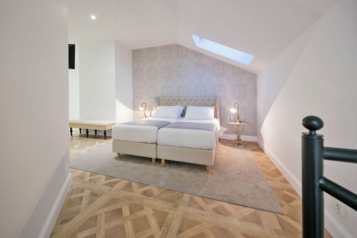Quarto com uma cama grande, claraboia e design moderno.