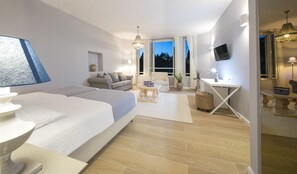 A modern hotel room with a large bed, a desk, and a seating area. - Aminess Vival Port9 Resort  (Korcula)