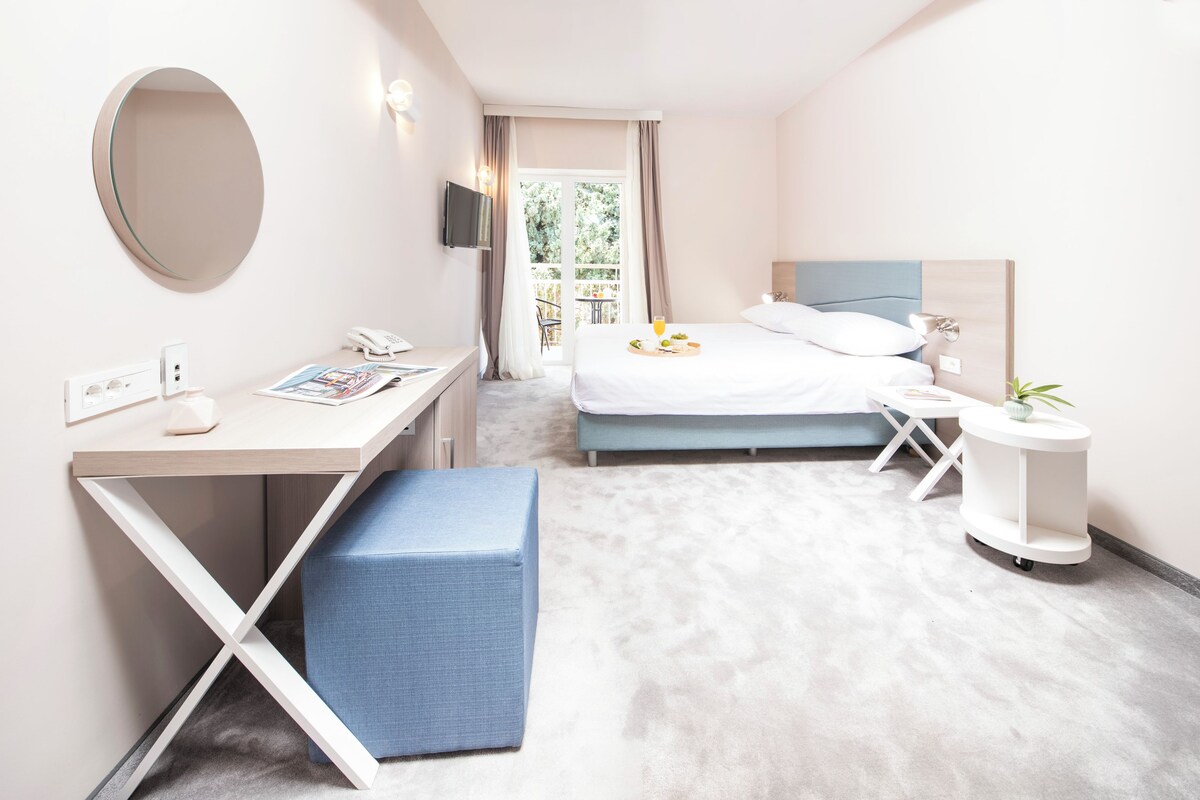 A modern bedroom with a bed, bedside table, and a desk with a chair.