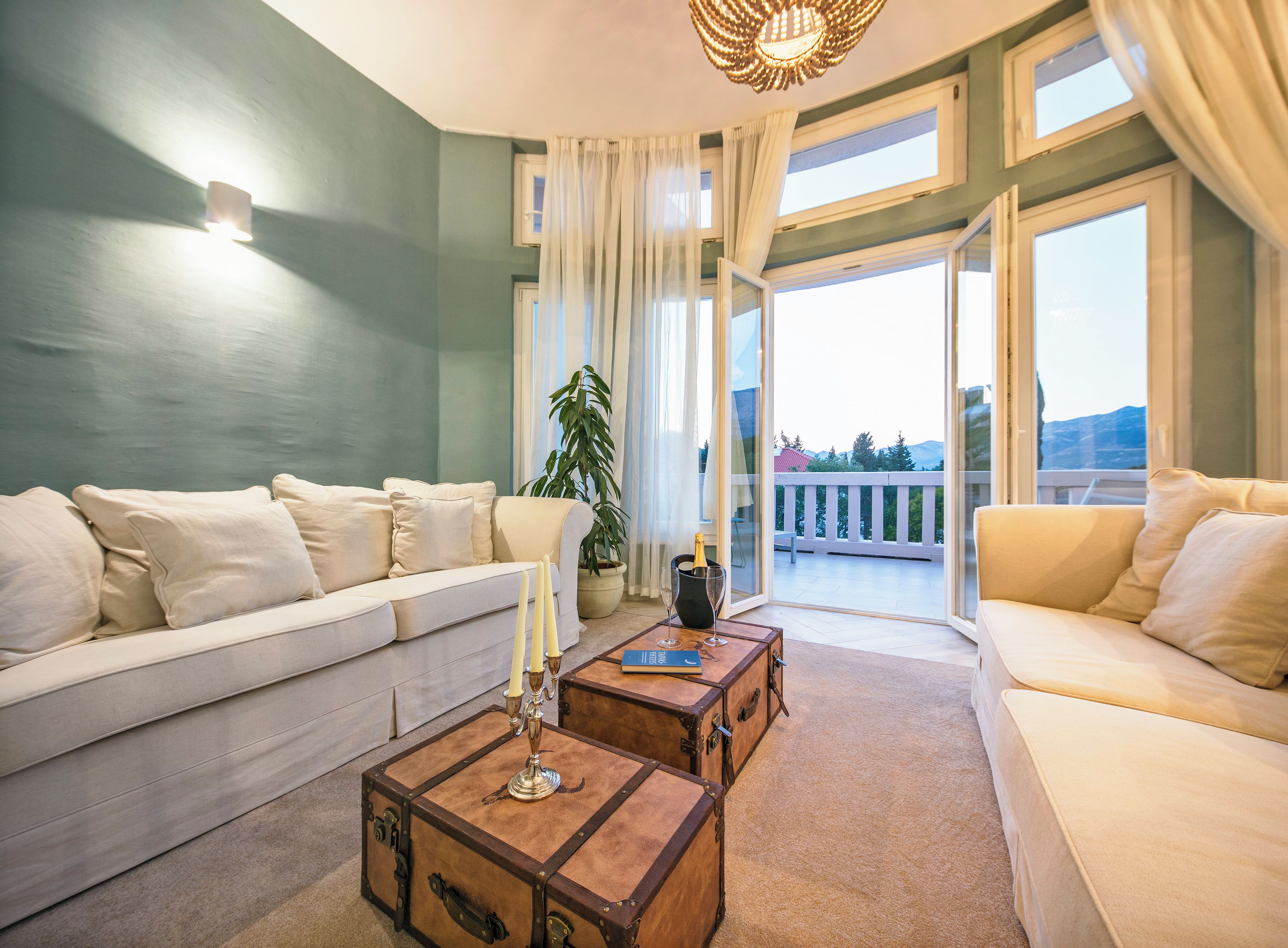 A spacious living room with a sofa, a coffee table, and a view of a balcony.