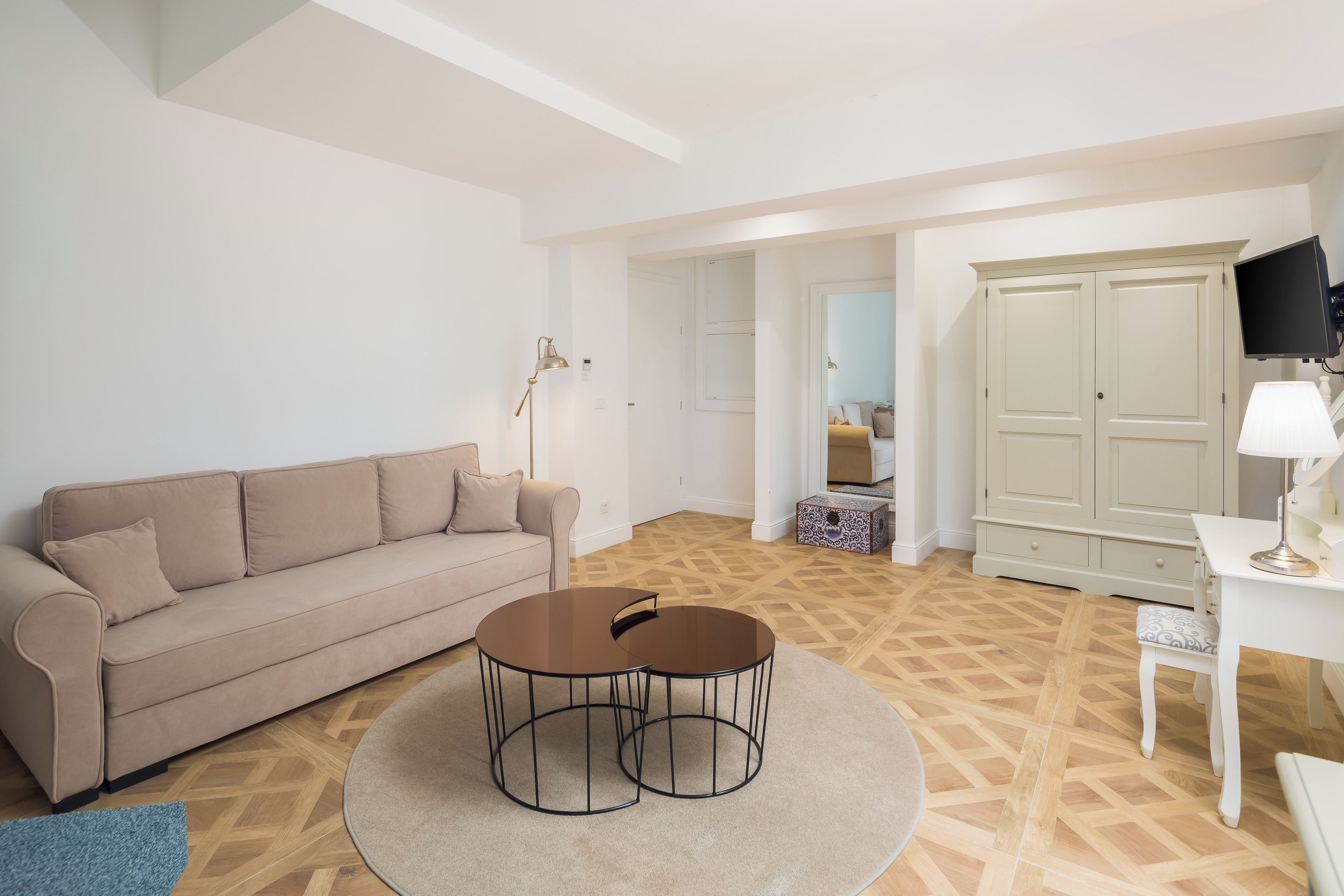 A living room with a sofa, a coffee table, a TV, and a wardrobe.