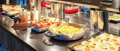 A buffet with various food items including eggs, cheese, and sauces.