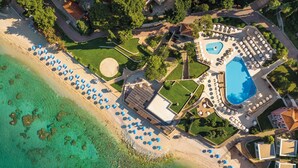 Vista aérea de un resort con playa, piscina y varias zonas de descanso.