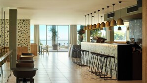 Una cocina moderna con barra, ventanas amplias y vistas al mar.