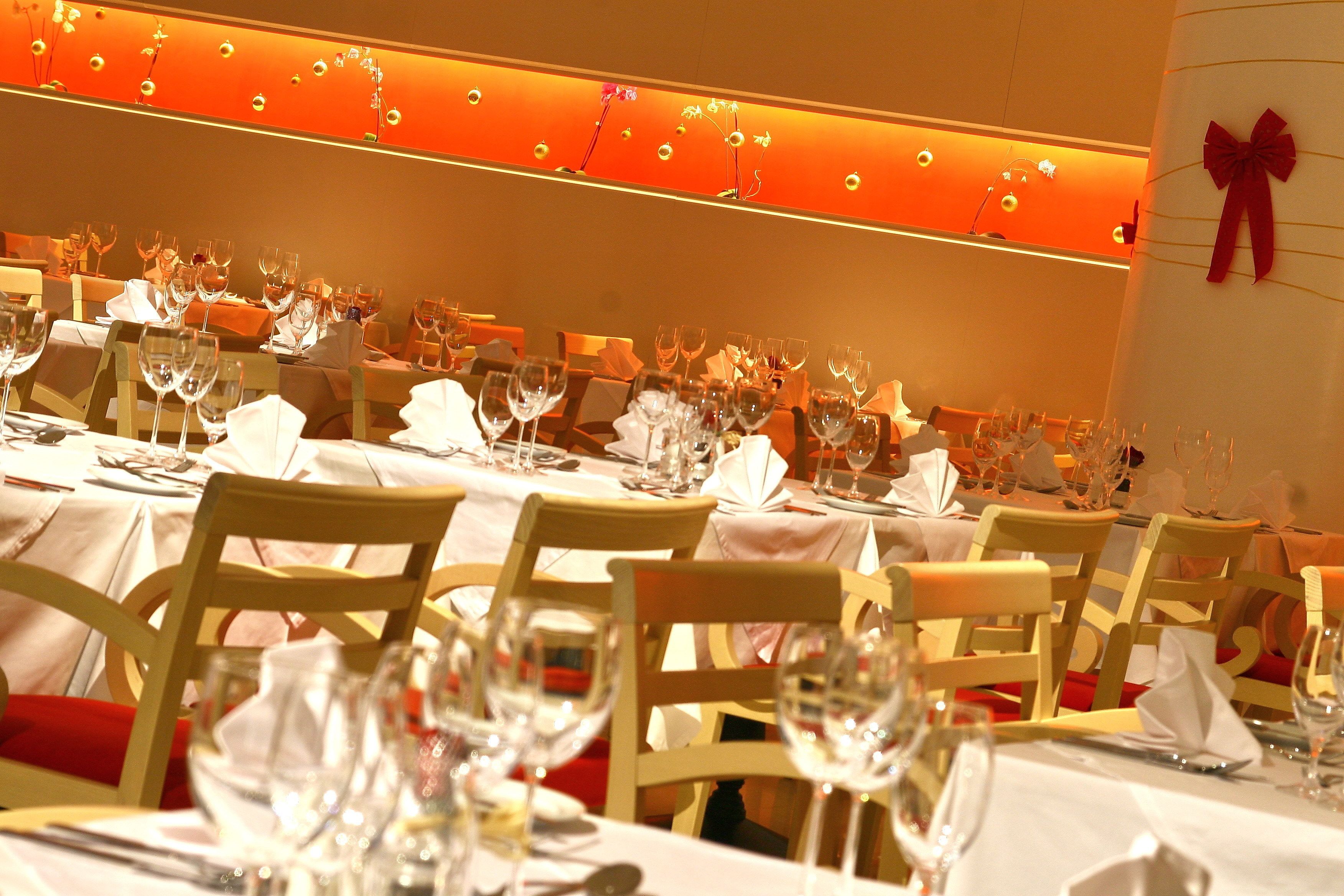 A restaurant with multiple tables set for dining, each with wine glasses and cutlery.