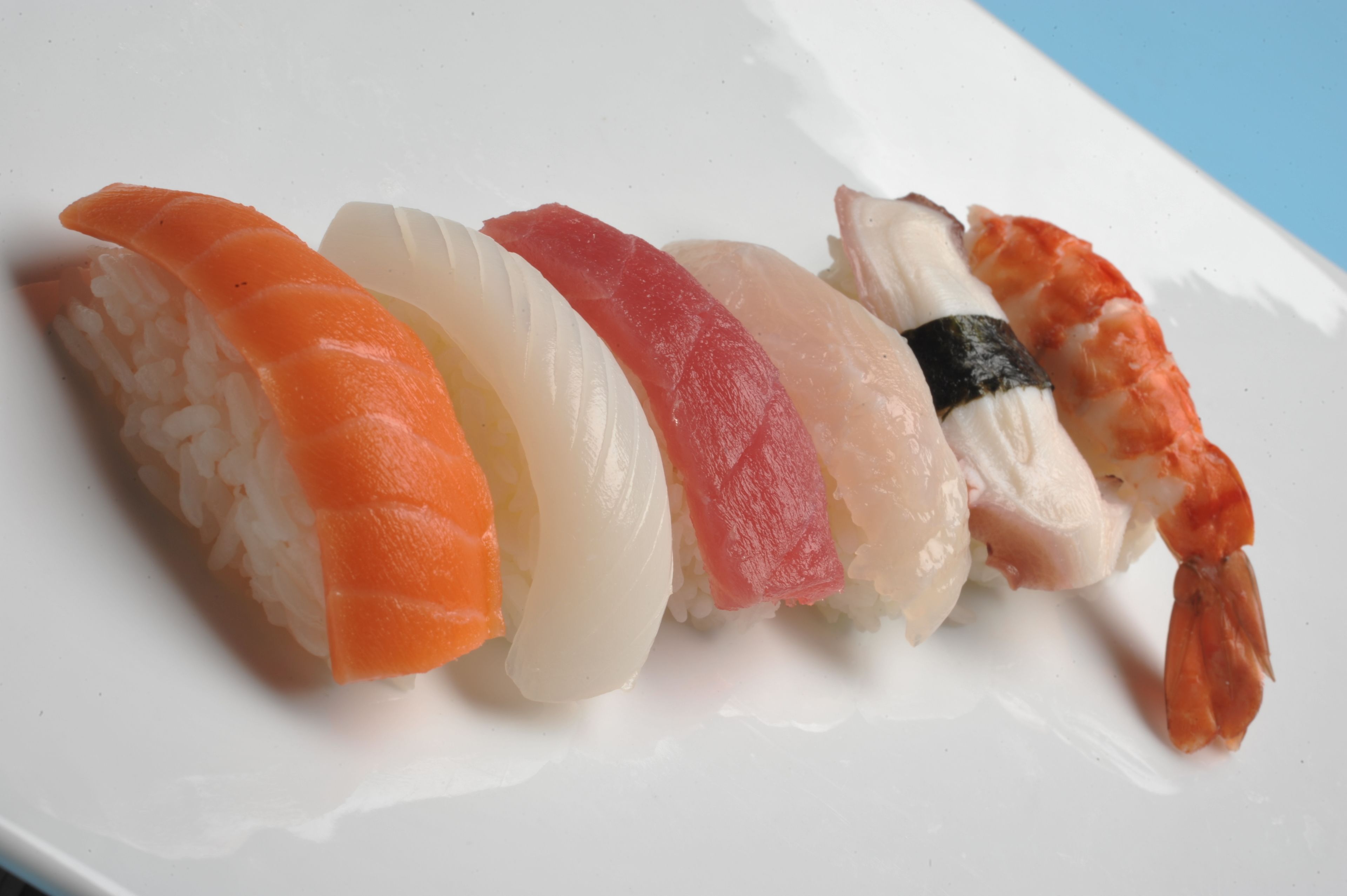 A plate of sushi with various types of fish and rice.