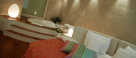 Habitación de hotel con cama, un espejo grande, un lavabo y ducha.