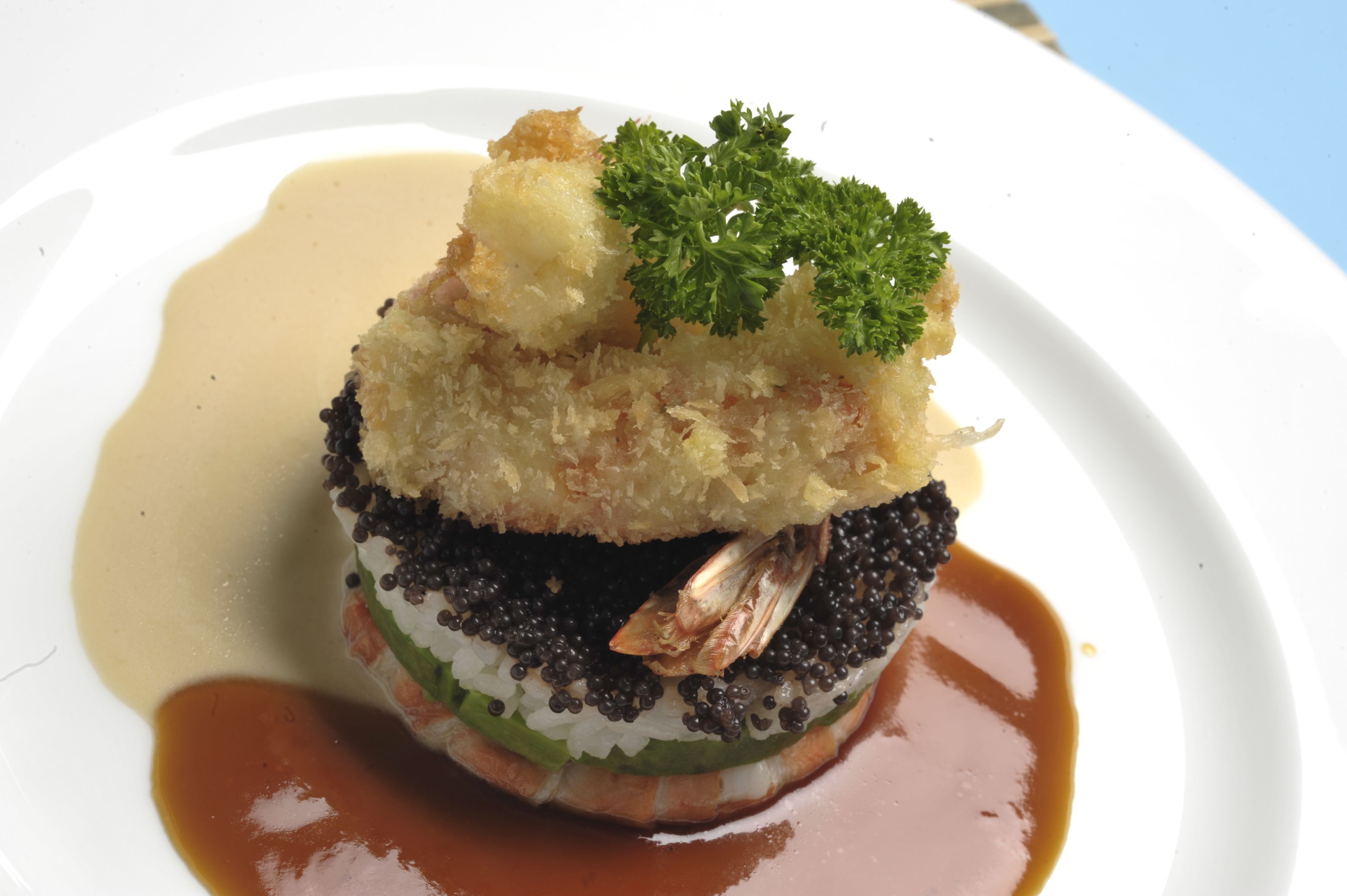 Un plato de mariscos, arroz y una guarnición sobre una vajilla blanca.