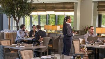A restaurant with a waiter serving guests at a table.