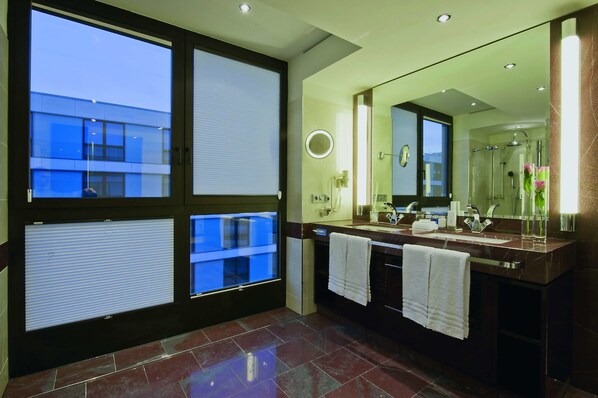 A modern bathroom with a large mirror, two sinks, and a shower area. - Maritim Hotel Düsseldorf (Düsseldorf)