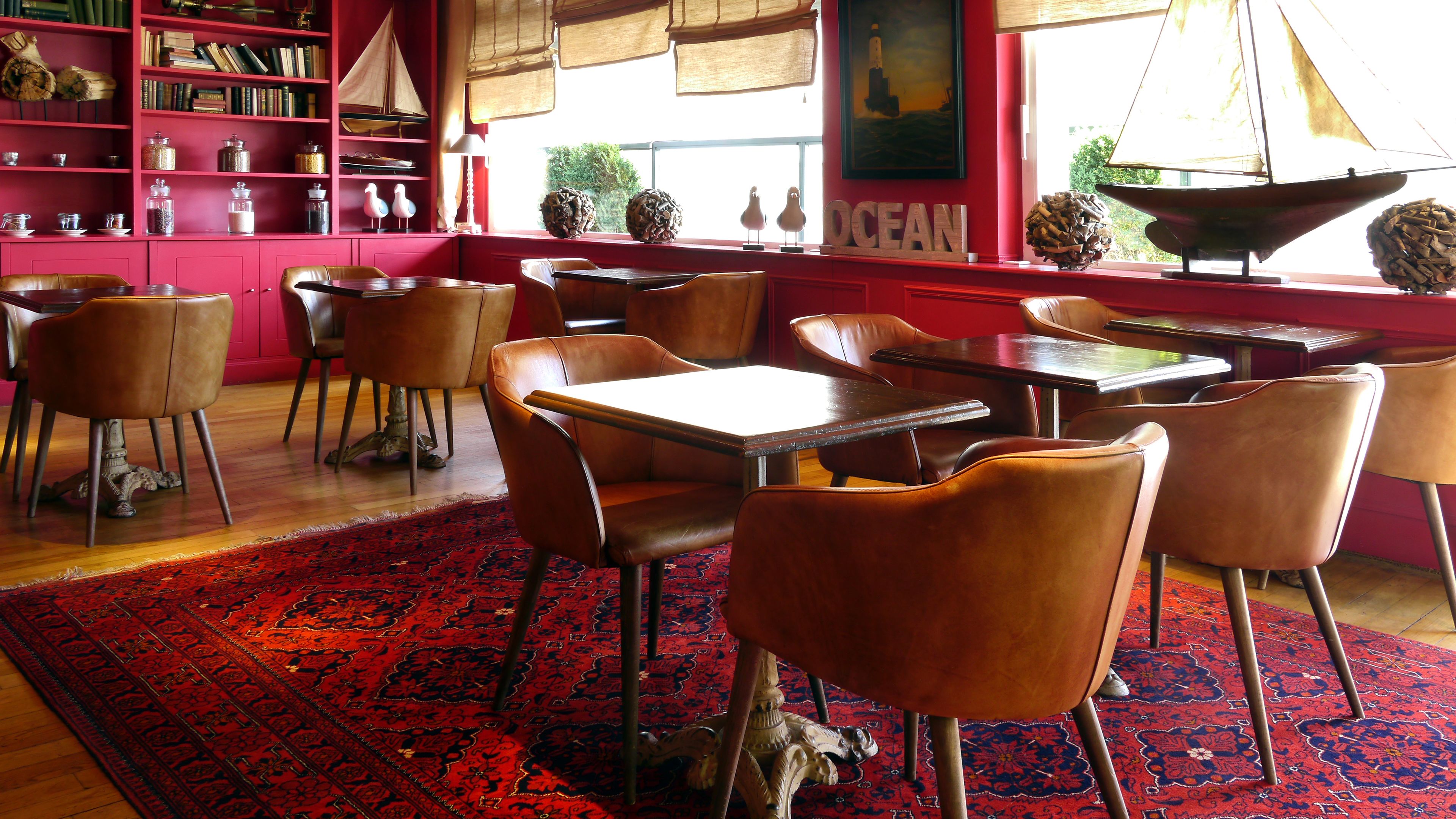 Un restaurant chaleureux avec des murs rouges, des tables en bois et des chaises en cuir.