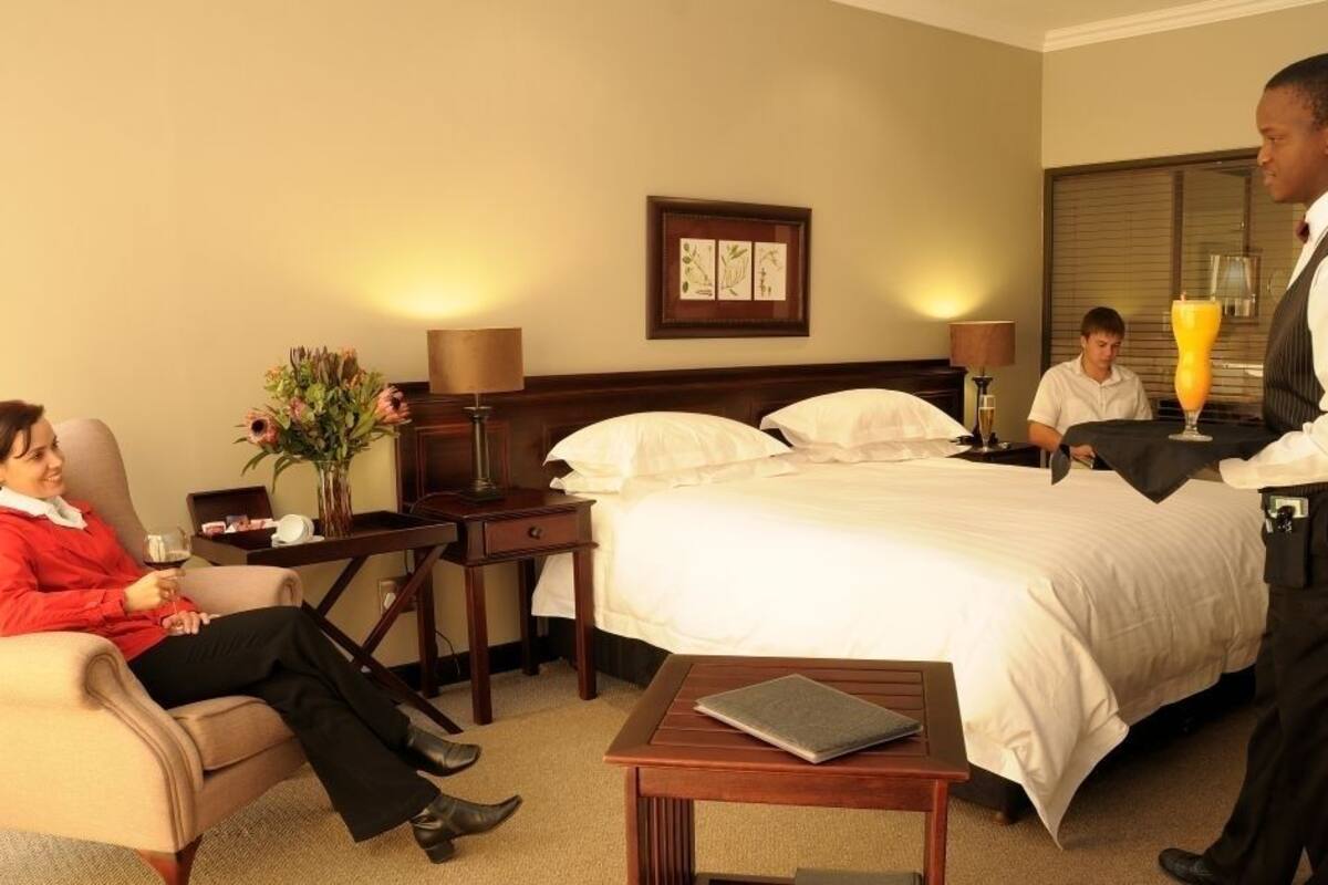 Una habitación de hotel con cama, mesitas de noche, un escritorio y una silla.