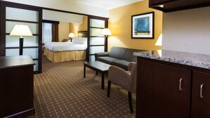 A hotel room with a bed, a sofa, a desk, and a dining table. - Holiday Inn Express & Suites Allentown West by IHG (Allentown)