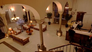 En rummelig lobby med flere siddeområder, en receptionsdisk og en trappe til de øvre etager.