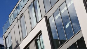 A modern building with multiple floors, large windows, and a clear sky. - The Spires Serviced Apartments Birmingham (Birmingham)