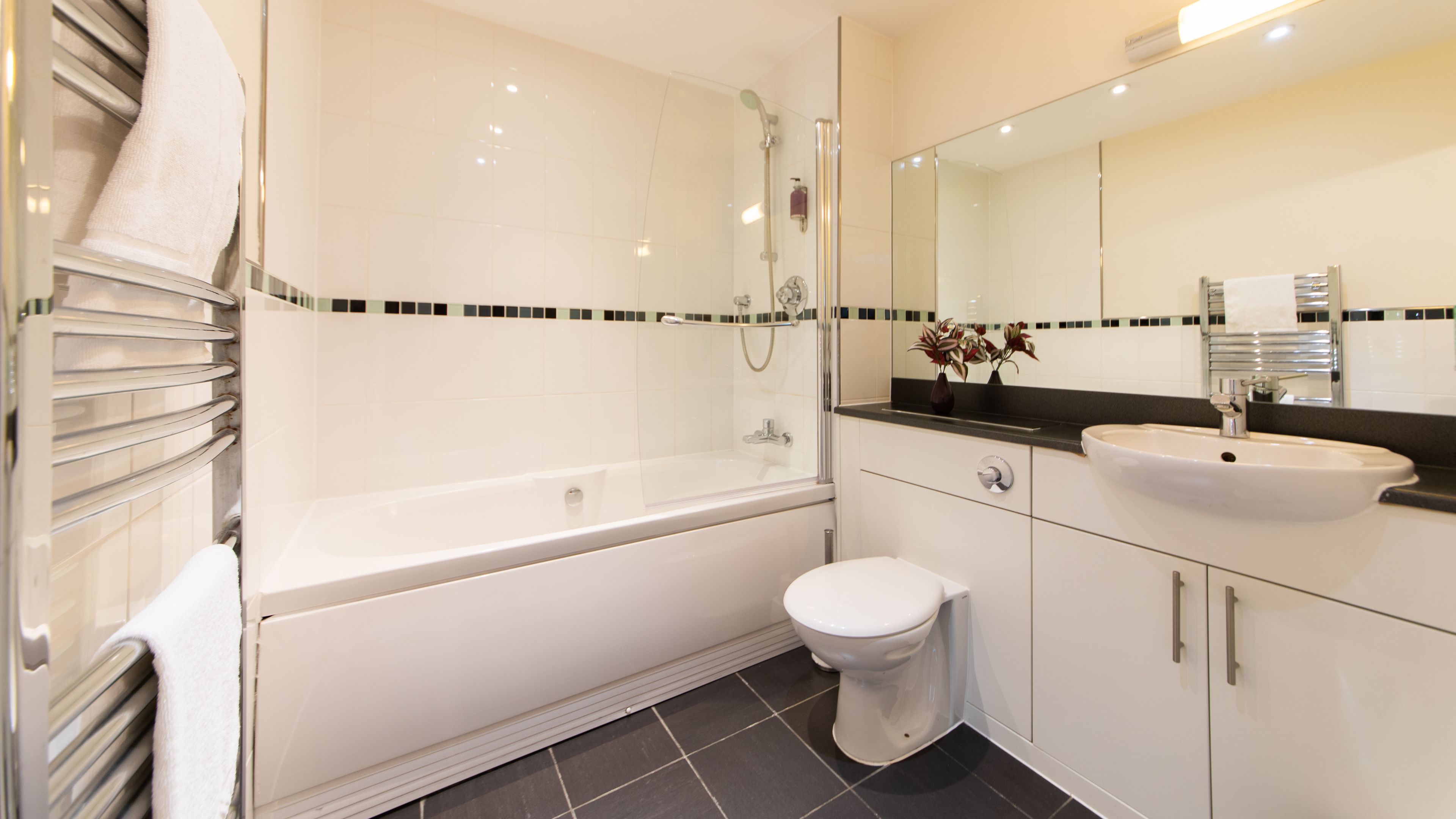 A modern bathroom with a bathtub, toilet, and sink.