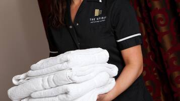 A person holding a stack of white towels.