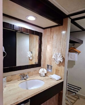 A bathroom with a wooden vanity, a large mirror, a sink, and a towel rack. - Best Western Hotel Posada Freeman Zona Dorada (Mazatlán)
