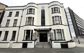 Un edificio de varios pisos con una entrada destacada que indica 'Lord Nelson Hotel'.