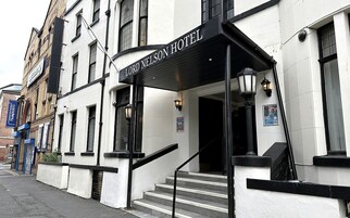 Entrada de un hotel con un letrero que dice 'Lord Nelson Hotel'.