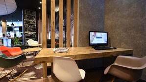 Una moderna zona de recepción con un mostrador de madera, computadora y asientos.