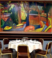 Comedor con una mesa redonda dispuesta para seis personas, rodeada de cuatro sillas.
