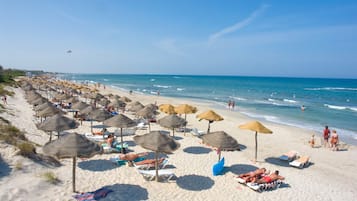 Privat strand, vit sandstrand, solstolar och parasoller