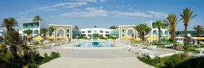 A resort with a central swimming pool, multiple lounge areas with umbrellas, and palm trees. - El Mouradi Cap Mahdia (Mahdia)