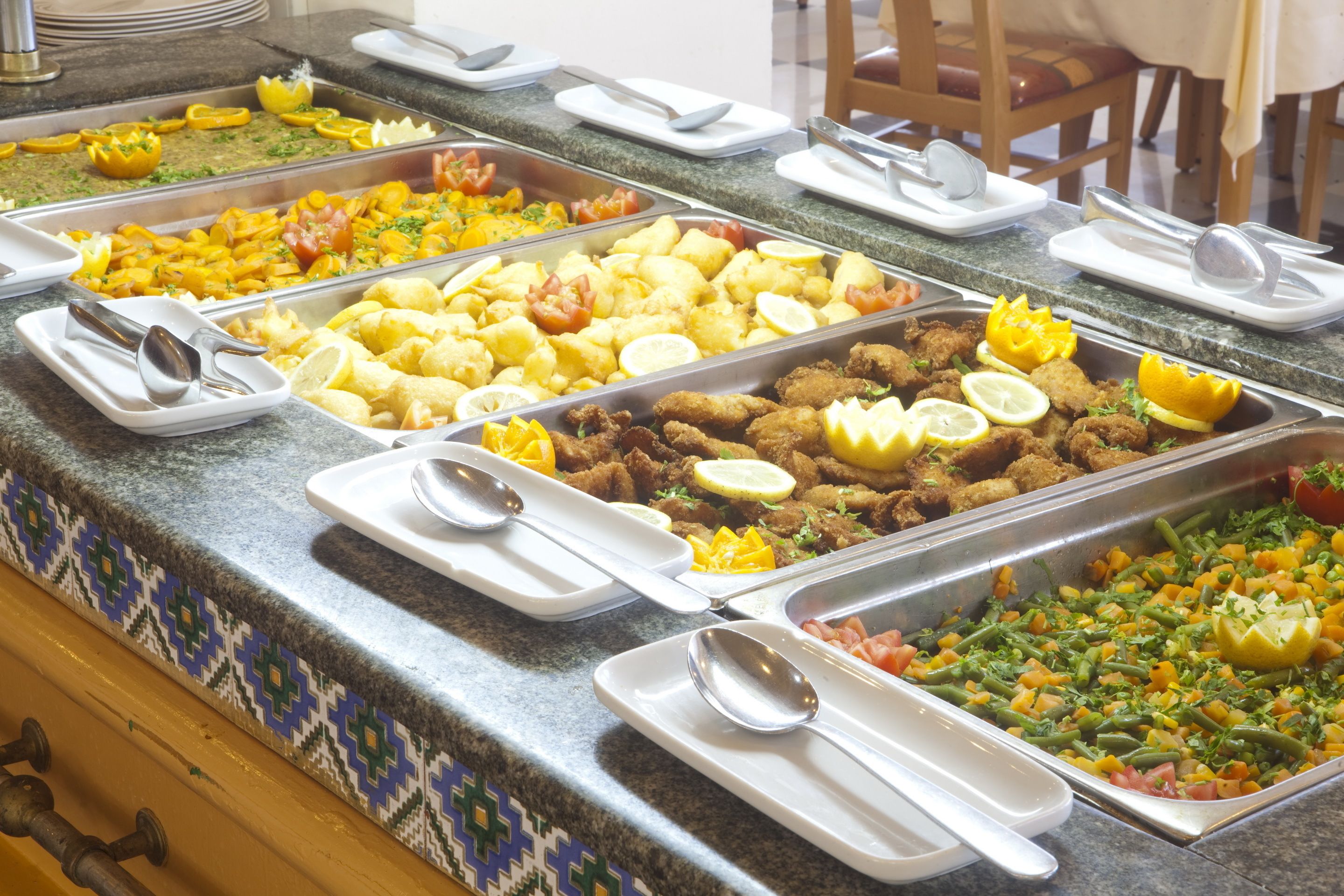 A buffet with various food items and serving utensils.