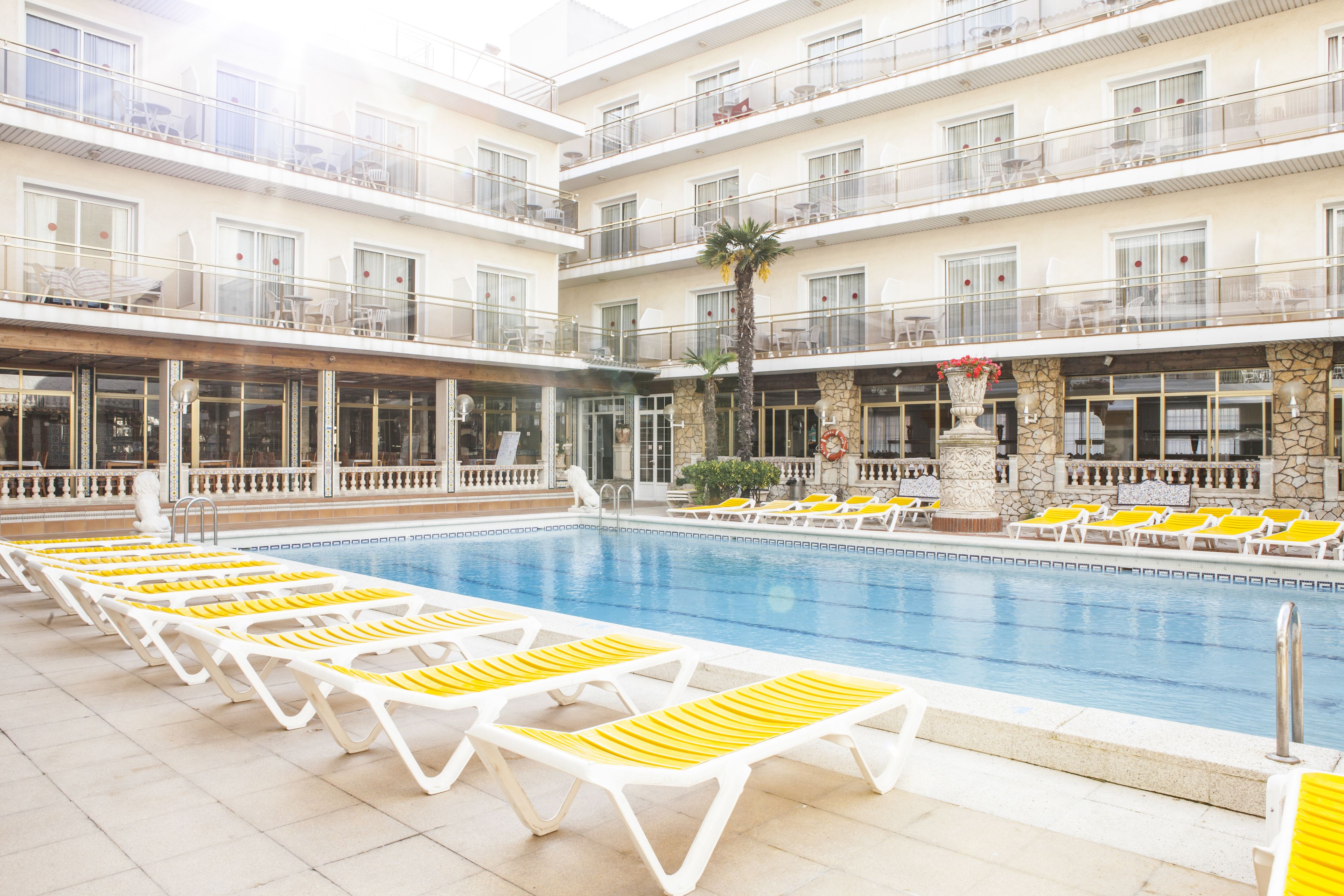 Een buitenzwembad en ligstoelen