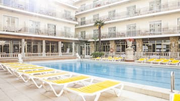 Een buitenzwembad en ligstoelen