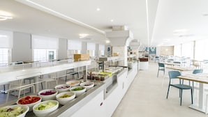 Una cafetería moderna con varias estaciones de comida y zonas de estar.