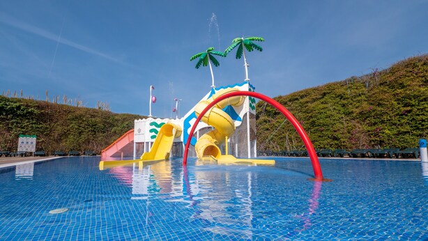 A swimming pool with a water play area featuring slides and a water slide. - Santa Susanna Resort Affiliated by FERGUS (Santa Susanna)