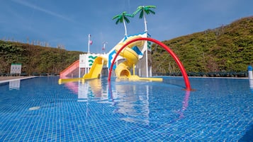 En sÀsongsöppen utomhuspool, parasoller och solstolar