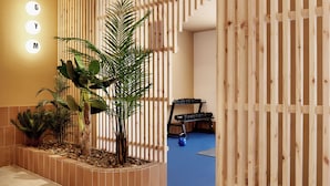 Un área de gimnasio con listones de madera, una colchoneta azul para ejercicios y un soporte para mancuernas.