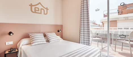 A hotel room with a bed, a nightstand, a phone, and a window with a view of the outside.