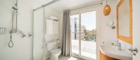Une salle de bain moderne avec une douche à parois de verre, des toilettes et un lavabo avec un meuble-vasque en bois.