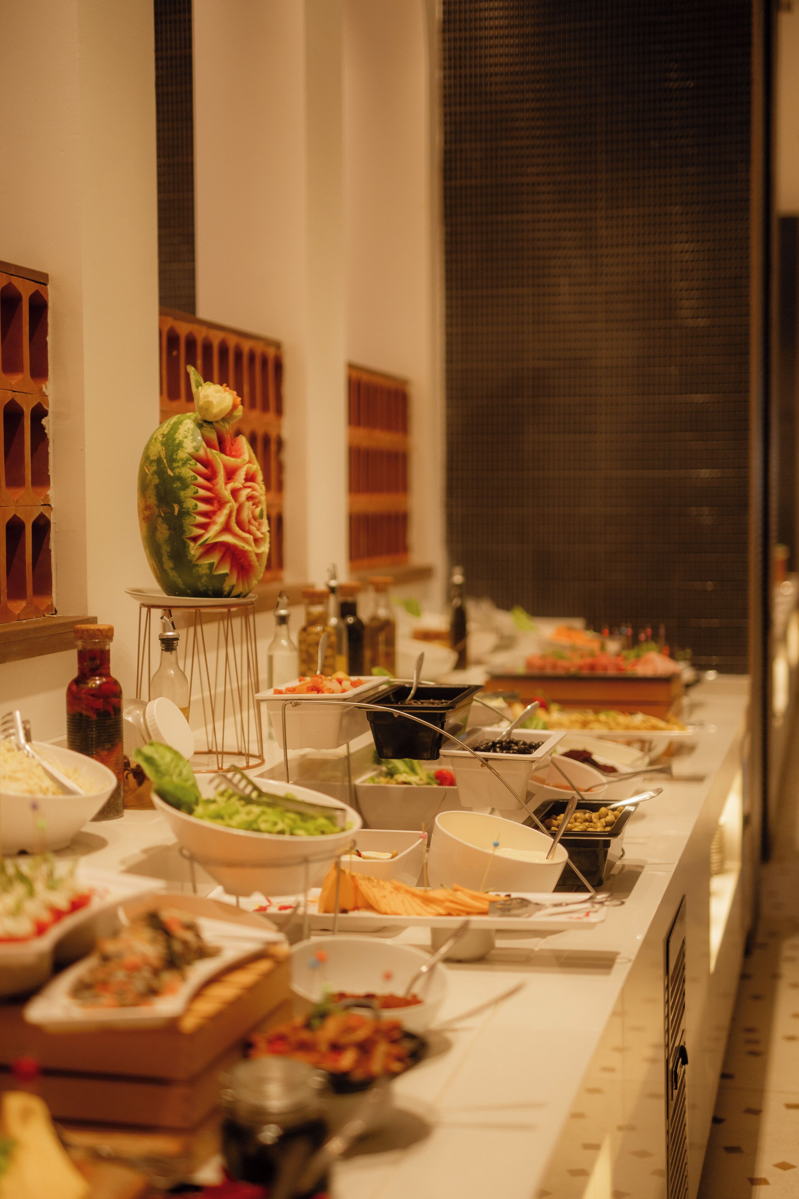 A buffet setup with various food items and a decorative centerpiece.