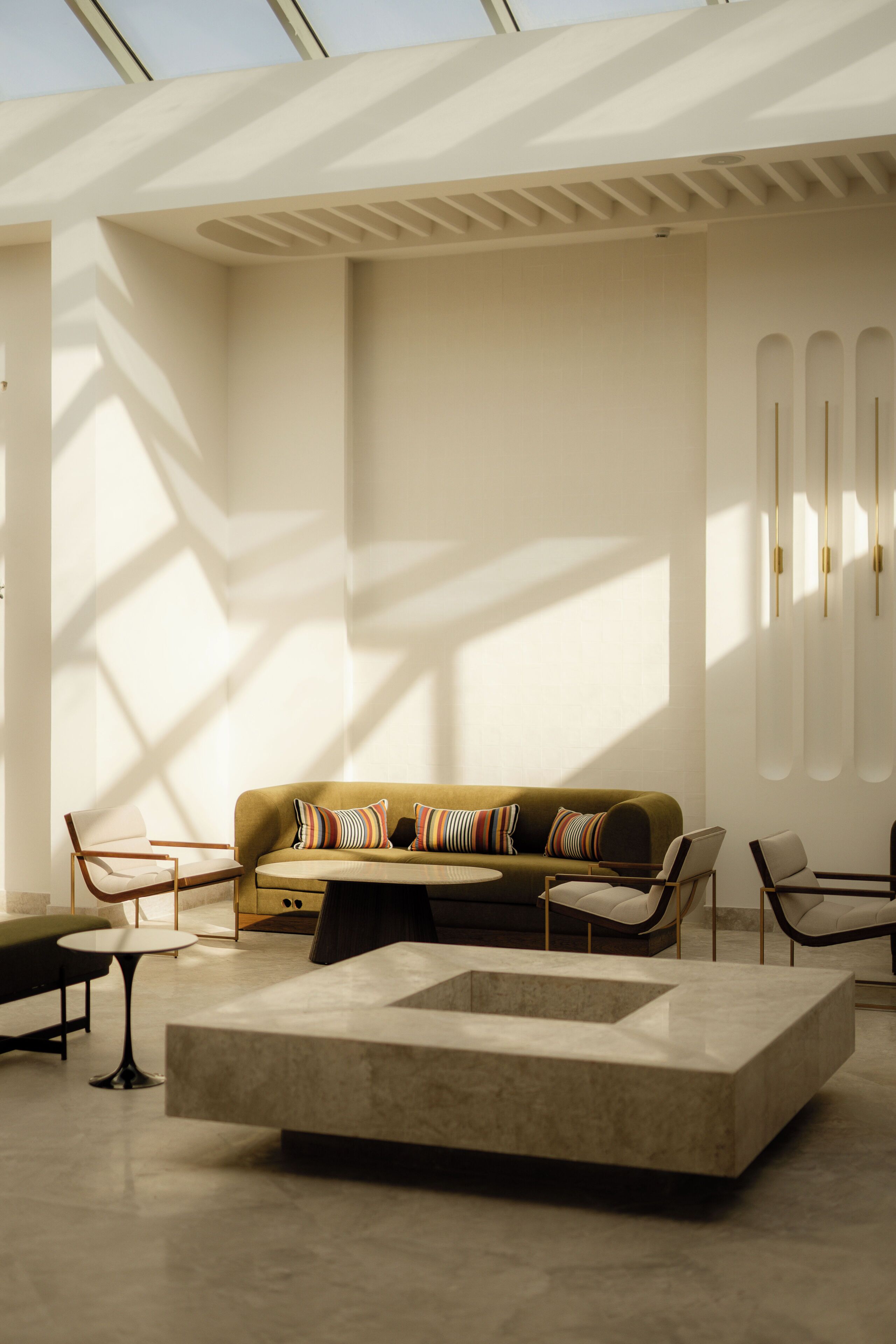 A modern interior with a sofa, chairs, a coffee table, and a geometric floor design.