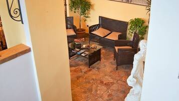 A staircase leading to a living area with a sofa, a coffee table, and a potted plant.