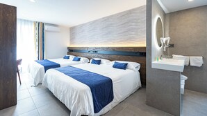 Quarto de hotel moderno com duas camas, um espelho grande, pia embutida e vista para a cidade.